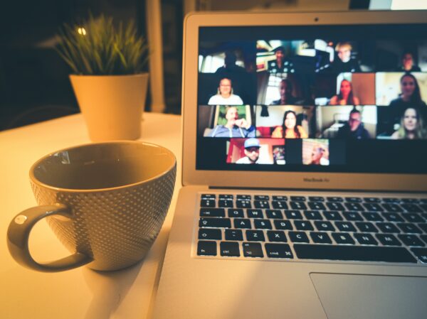 Zoom class on a computer with a mug and plant beside it