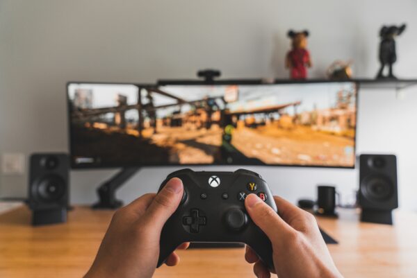 Playing video games using a black xbox controller in front of the TV